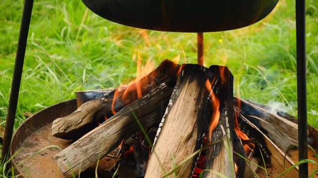 Close up of black pan on campfire. Camp on travel, place for bonfire. Cooking outdoor. Survival in wild adventure	