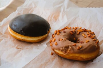 chocolate donuts and almond donuts on a paper
