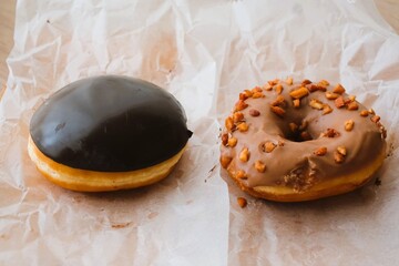 chocolate donuts and almond donuts on a paper
