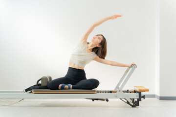 ピラティス女子 日本人女性がリフォーマーでポーズ