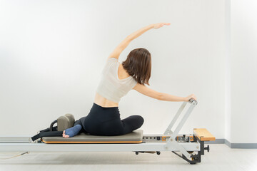 ピラティス女子 日本人女性がリフォーマーでポーズ