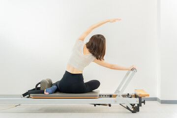 ピラティス女子 日本人女性がリフォーマーでポーズ