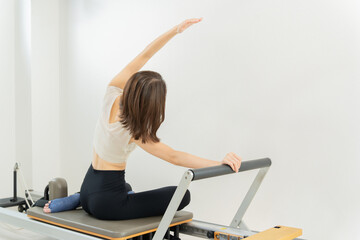 ピラティス女子 日本人女性がリフォーマーでポーズ