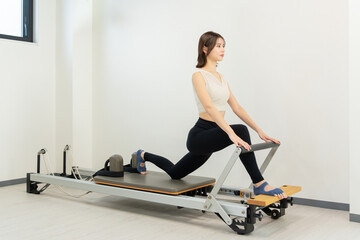 ピラティス女子 日本人女性がリフォーマーでポーズ