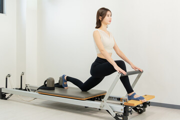 ピラティス女子 日本人女性がリフォーマーでポーズ