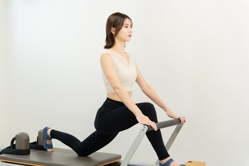 ピラティス女子 日本人女性がリフォーマーでポーズ