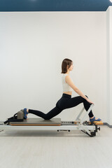 ピラティス女子 日本人女性がリフォーマーでポーズ