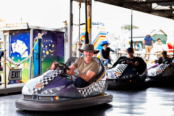 Bumper cars ride with Aussie man riding dodgem car at carnival show ride smiling