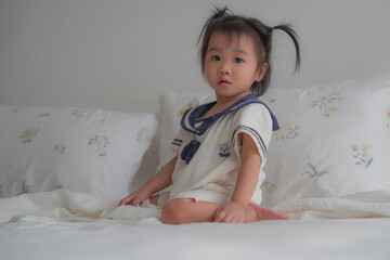 Cute baby lying on bed in soft natural light