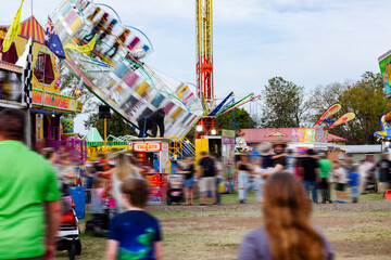 Blurred crowd and show ride down sideshow alley at local agricultural show event