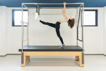 ピラティス女子 日本人女性がキャデラックでポーズ