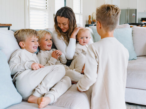 Young boys snuggling with mum on the couch