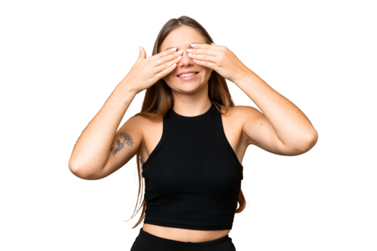 Young blonde woman over isolated chroma key background covering eyes by hands and smiling