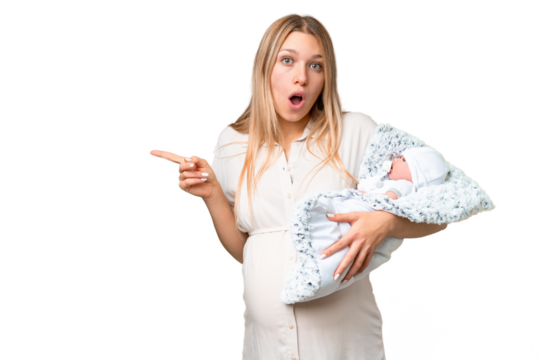 Young pretty pregnant woman with her newborn baby over isolated chroma key background surprised and pointing side