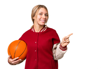 Young hispanic woman playing basketball over isolated white background pointing finger to the side