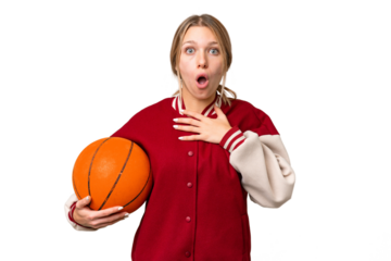 Young hispanic woman playing basketball over isolated white background surprised and shocked while looking right