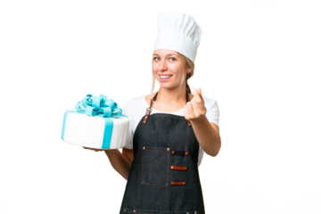 Young pastry blonde woman with a big cake over isolated chroma key background making money gesture