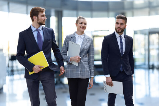 businesspeople group walking at modern bright office interior.
