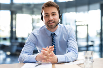 Fototapeta premium Smiling friendly handsome young male call centre operator.