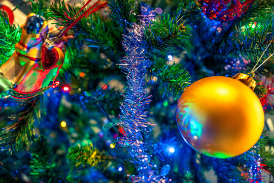 Christmas tree decorations with tinsel and vibrant colored lights, garlands and balls.