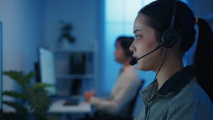 Closeup Gen z Asia young call center team or customer support service executive use computer and microphone headset work technical e commerce in late night office. Telemarketing or sales job concept. - Powered by Adobe