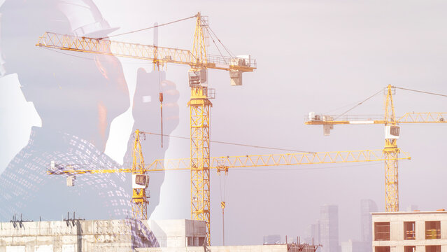 A construction worker in safety gear is seen giving instructions on a walkie-talkie against a backdrop of a construction site with construction cranes. They are responsible for organizing the