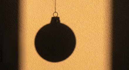 Festive holiday spirit with a shadow of Christmas ornament shining on textured yellow wall, perfect for seasonal greetings and cozy winter projects