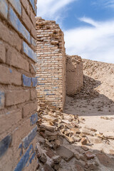 Remnants of a historical brick wall stand against a clear blue sky in Uruk, Iraq, showcasing ancient craftsmanship and heritage