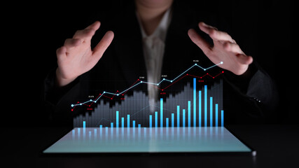A businessman engages with virtual data visualization, analyzing graphs and charts with raised...