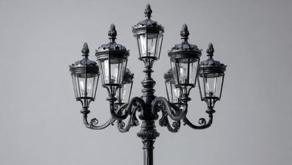 An elegant, ornate vintage multi-lamp street light in monochrome, showcasing intricate metalwork and clear glass lanterns against a minimalist grey background.