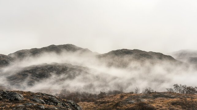 Fog rolling over rugged mountains in a misty landscape