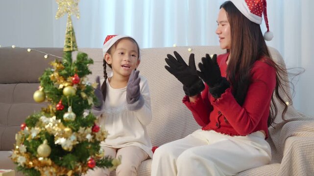 Christmas family home holiday celebrating, happy parent and kid enjoy festive tree, making merry memories on special eve, clapping hands with joyful spirit during winter season.