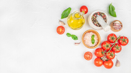 Fresh cooking ingredients with tomatoes, basil, garlic, olive oil and spices on white background, top view, copy space