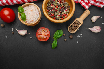 Assorted cooking ingredients and spices on dark textured background with copy space