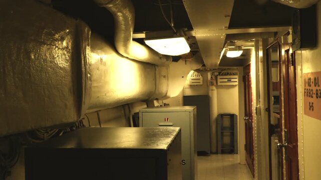Sideways tracking shot inside World War II battleship corridor with narrow steel passage and industrial detail