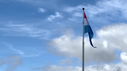 Luxembourg flag waving against blue sky - Powered by Adobe