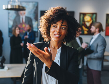 Confident businesswoman presenting with colleagues in background. Captures leadership, modern teamwork, diversity. Ideal for corporate presentations, success. - Powered by Adobe
