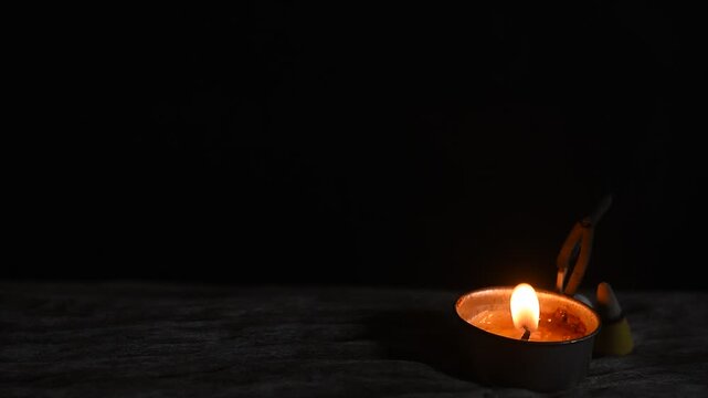 Aromatherapy with incense and candle on black ceramic background.