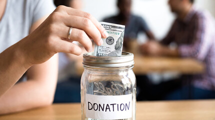 Woman hand putting coin in donation jar glass money charity fundraising support finance help humanitarian aid community budget investment kindness social work concept savings banking lifestyle giving