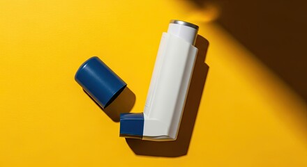 A respiratory inhaler for allergy and asthma relief, lying open on a vibrant yellow surface under harsh, direct sunlight creating a bold, graphic shadow
