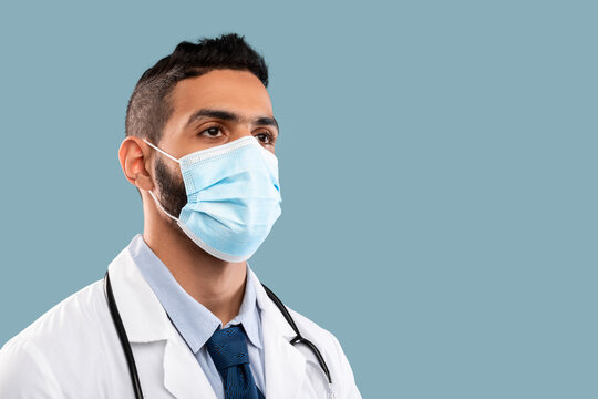 A healthcare worker stands confidently with a mask covering his face and a stethoscope around his neck. He is prepared to assist patients during a health crisis.