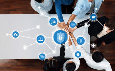 A top view of a diverse team collaborating on a cybersecurity strategy, surrounded by digital security icons symbolizing modern data protection and technological innovation. Amity