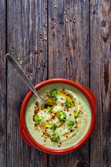 Cream of broccoli soup on wooden table. Top view