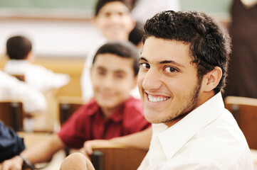 Happy children with their teacher in classroom, doing