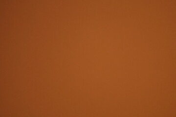 A soft, abstract, and moody background texture with a gentle, out-of-focus red and orange light leak on a brown backdrop.