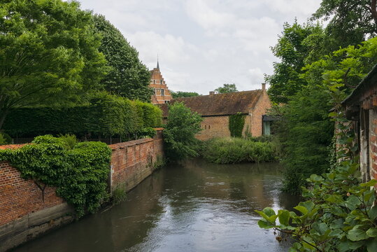 Tranquil view of the Dyle river and brick walls within the Great Beguinage in Leuven, Belgium.