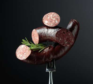 Spanish black pudding or blood sausage with rosemary on a fork.