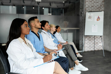 Professional multiethnic group of male and female healthcare employees having medical conference at...