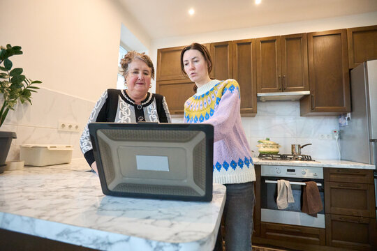 Family cooking together in modern kitchen with digital recipes