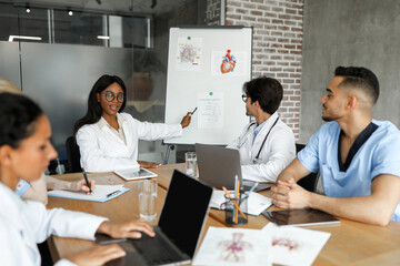 African american woman chief physician making presentation in front of male and female...